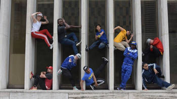 Δέκα break-dancers ποζάρουν σε διάφορες στάσεις, ενώ κάποιοι κρατιούνται ανάμεσα σε δύο τοίχους